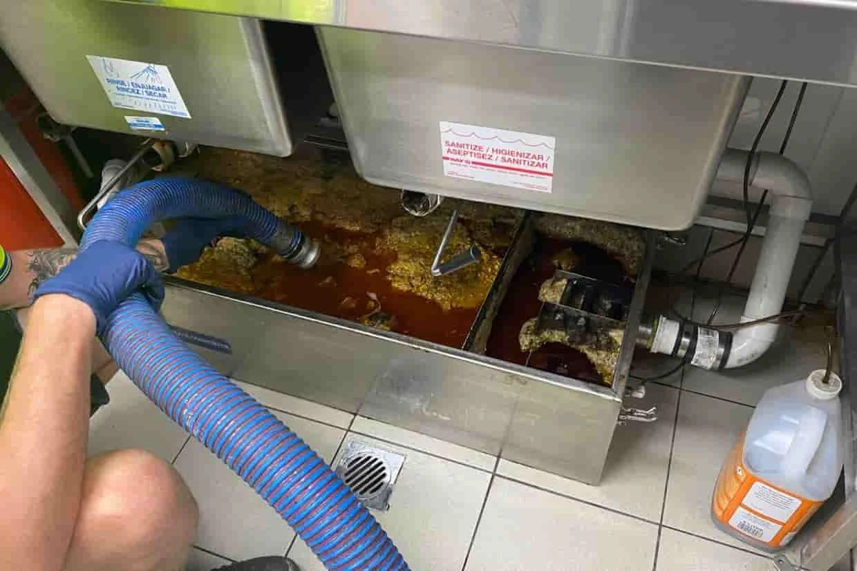 Grease interceptor being serviced in a commercial kitchen